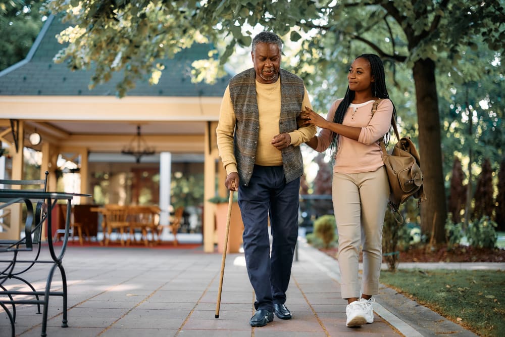 Happy woman walking with her senior father outdoors